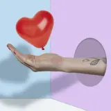 Mano che offre un palloncino a forma di cuore rosso, simbolo di frasi sull'amore puro.
