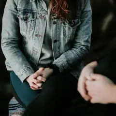 Due persone si tengono per mano, una con una giacca di jeans. Potrebbe essere un momento di conforto per chi soffre di paura del sangue, nome comune per l'emofobia.