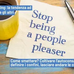 Tazza gialla, tovagliolo con scritto "Stop being a people pleaser" e penna. Psicologia: smettere di essere troppo disponibili.