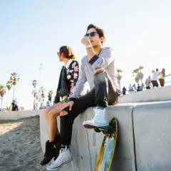 Due ragazzi seduti su un muretto, con uno skateboard. Un momento di riflessione, quasi un addio, quando un'amicizia finisce.