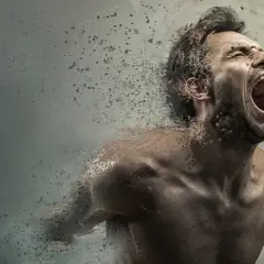 Uomo che urla, dissolvendosi in particelle, con un'espressione di profonda paura di impazzire.