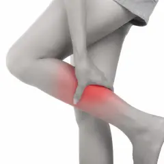 Donna che si tiene la gamba, evidenziata in rosso, a causa di dolori alle gambe da stress.