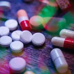 Pastiglie e capsule colorate su un tavolo di legno. L'aripiprazolo a cosa serve? Aiuta a trattare disturbi come schizofrenia e disturbo bipolare.