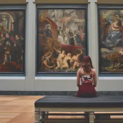 Una donna ammira tre grandi dipinti in un museo, forse provando la sindrome di Stendhal cos'è.