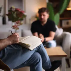 Un terapeuta ascolta e prende appunti, mostrando che il disturbo borderline si guarisce con il supporto giusto.