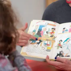 Donna legge un libro illustrato a un bambino, un momento di apprendimento che supporta il rinnovo certificazione DSA.