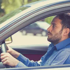 Uomo con espressione tesa al volante, forse a causa della paura di guidare.