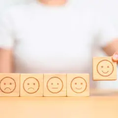 Una persona che se la prende subito, scegliendo un cubo con un sorriso tra faccine tristi e neutre.
