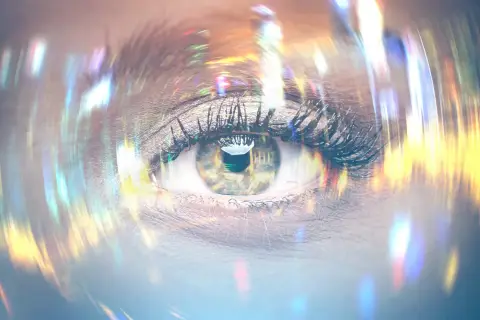 Occhio con ciglia lunghe e trucco, riflessi di luce colorata che sembrano lampi di luce negli occhi stress.
