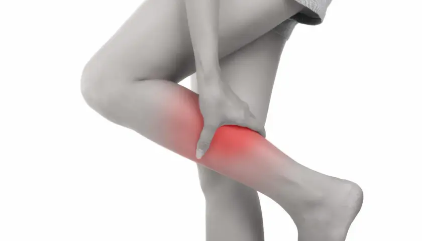 Donna che si tiene la gamba, evidenziata in rosso, a causa di dolori alle gambe da stress.