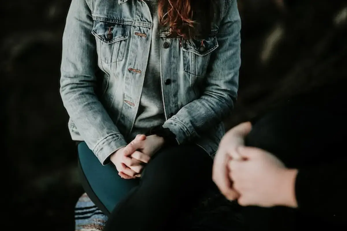 Due persone si tengono per mano, una con una giacca di jeans. Potrebbe essere un momento di conforto per chi soffre di paura del sangue, nome comune per l'emofobia.