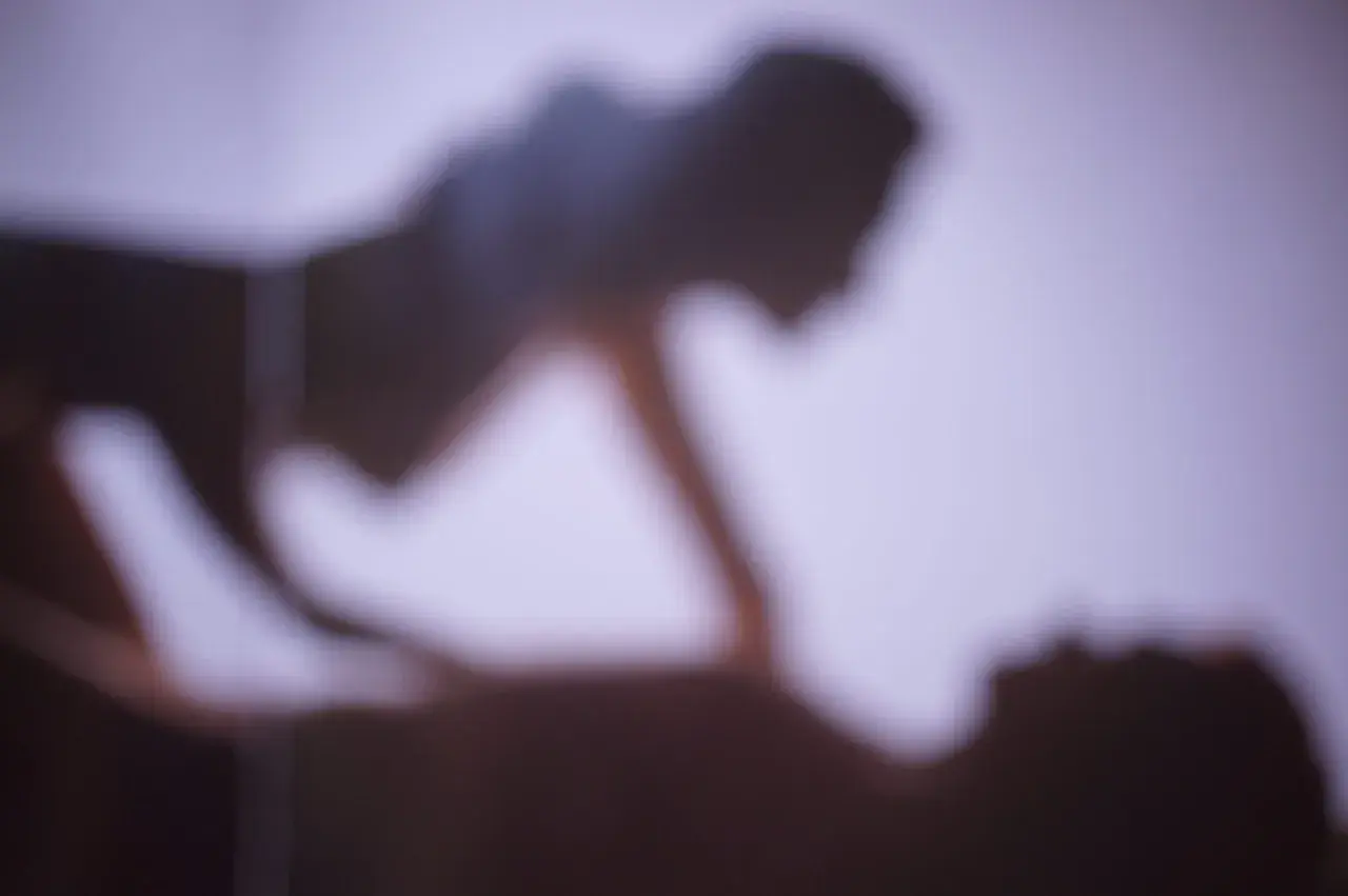 Ombre sfocate di due persone che si abbracciano, evocando la gioia e l'intimità della giornata mondiale dell'orgasmo.