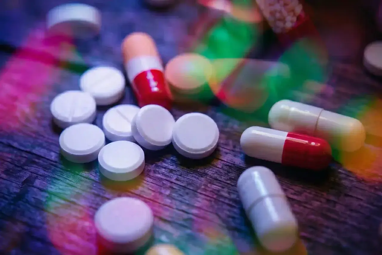 Pastiglie e capsule colorate su un tavolo di legno. L'aripiprazolo a cosa serve? Aiuta a trattare disturbi come schizofrenia e disturbo bipolare.