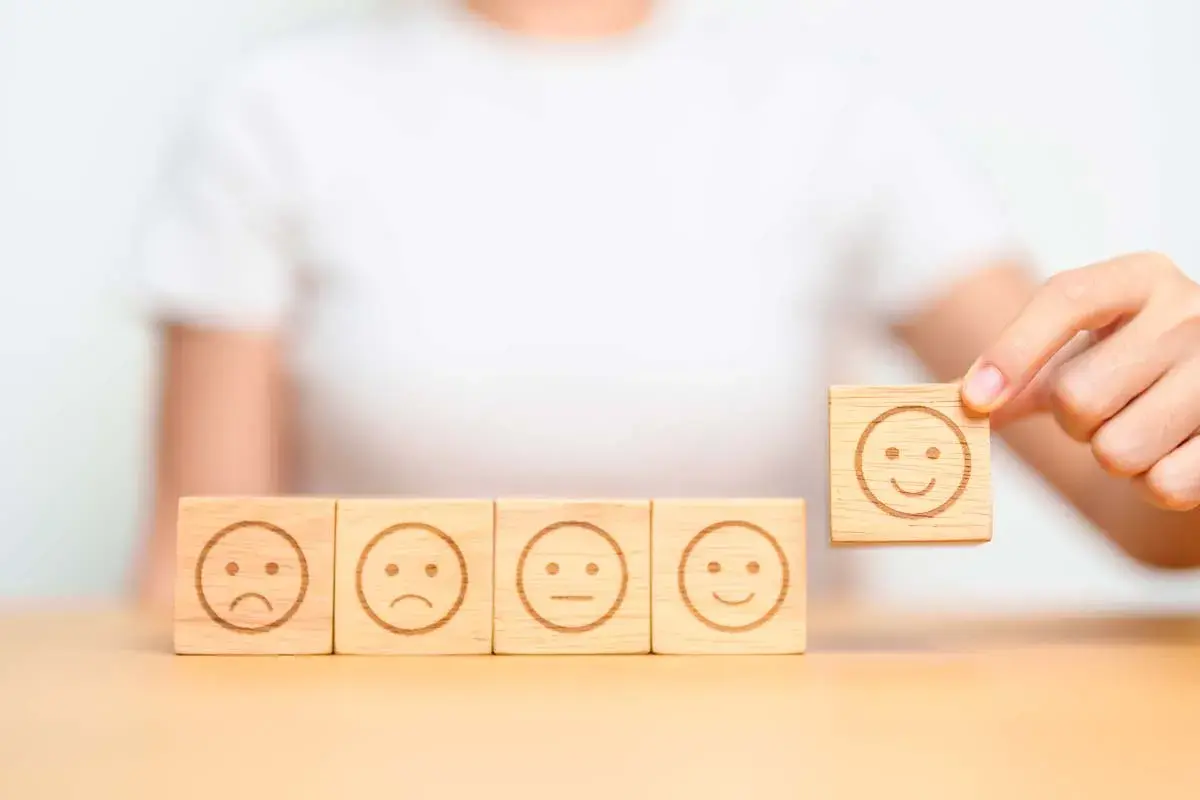 Una persona che se la prende subito, scegliendo un cubo con un sorriso tra faccine tristi e neutre.