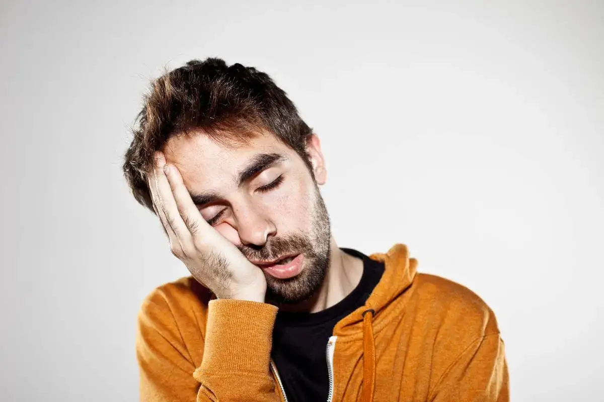Uomo con mano sul viso, occhi chiusi, bocca semiaperta. Sembra proprio che non riesco a svegliarmi la mattina.