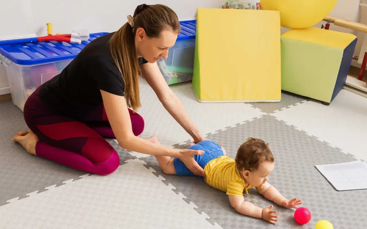 Bambino con disturbi del neurosviluppo in terapia, supportato da un terapista. La riabilitazione è fondamentale per la guarigione.