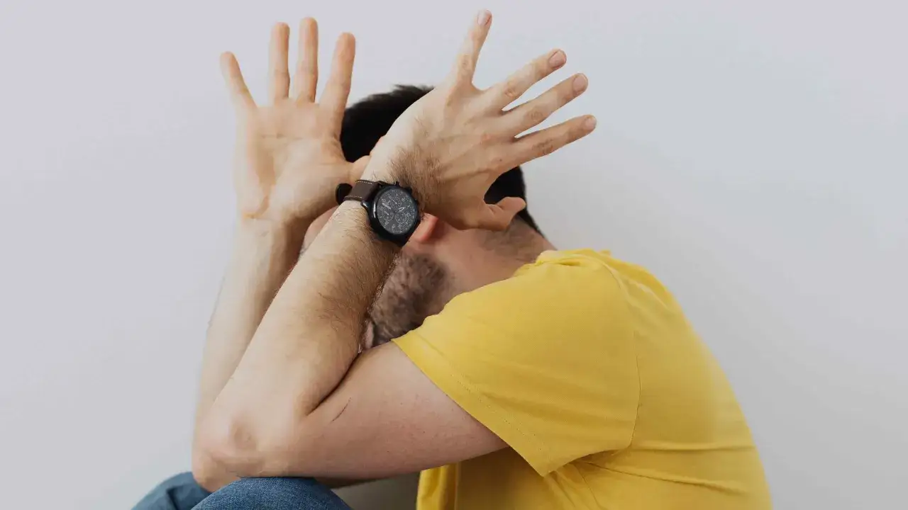 Uomo con le mani alzate a protezione del viso, forse per la paura delle cimici.