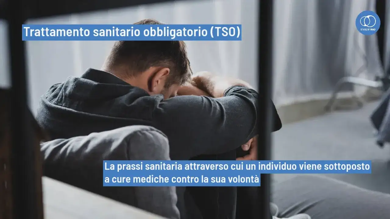 Uomo seduto con la testa tra le mani, simbolo di sofferenza. Il testo parla di ricovero in psichiatria e delle sue conseguenze.