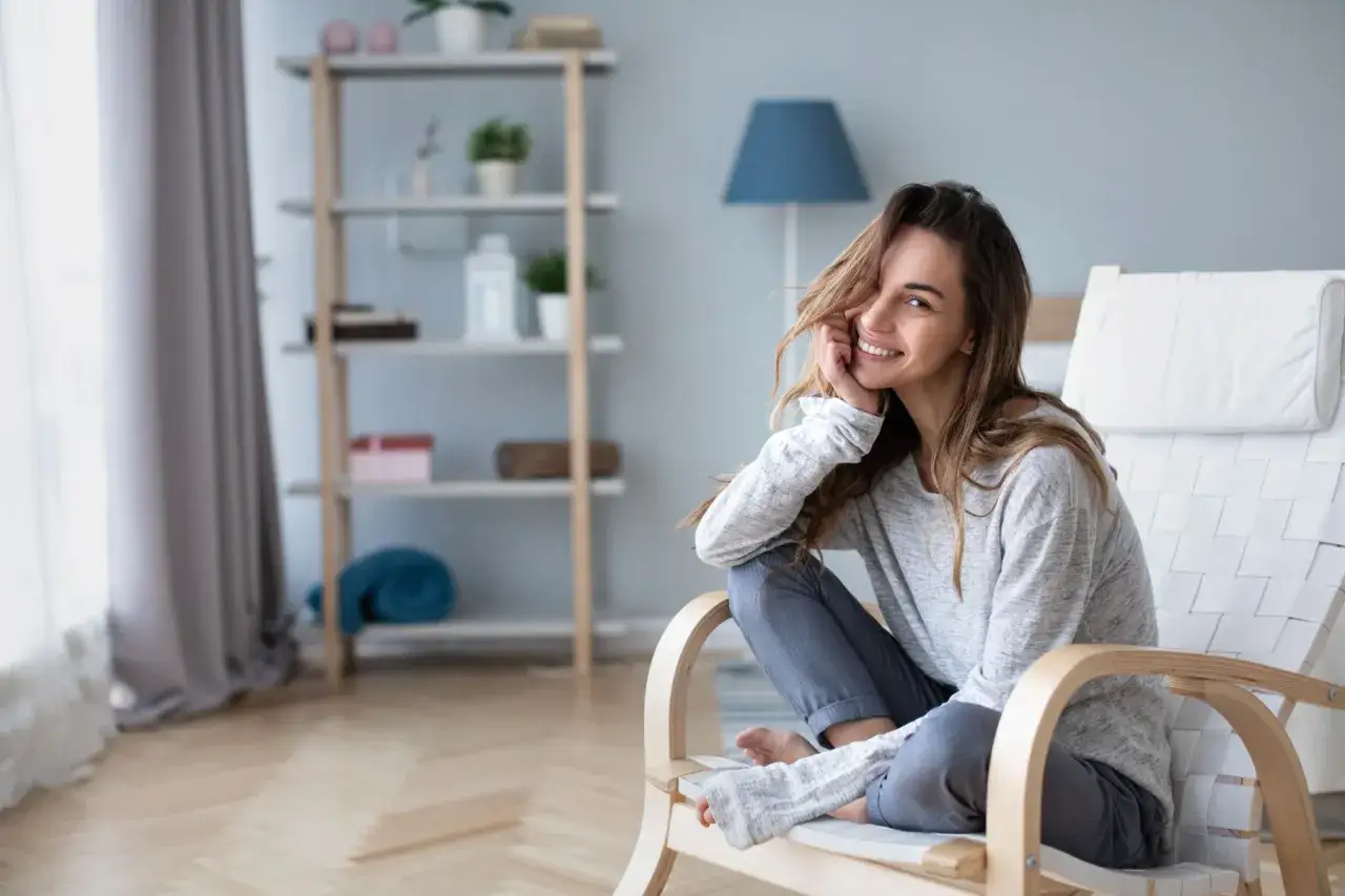 Donna sorridente in poltrona, serena nonostante la crisi di mezza età.