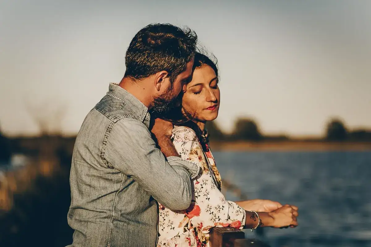 Coppia abbracciata al tramonto, un momento di serenit&agrave; che insegna come gestire la gelosia con amore e fiducia.