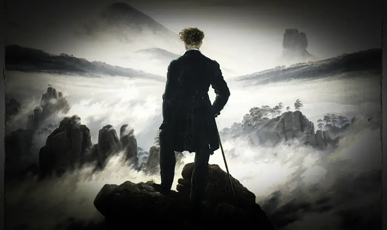 Uomo in piedi su una roccia, contemplando un paesaggio nebbioso. Un'immagine che evoca la crisi di mezza età e la ricerca di sé.