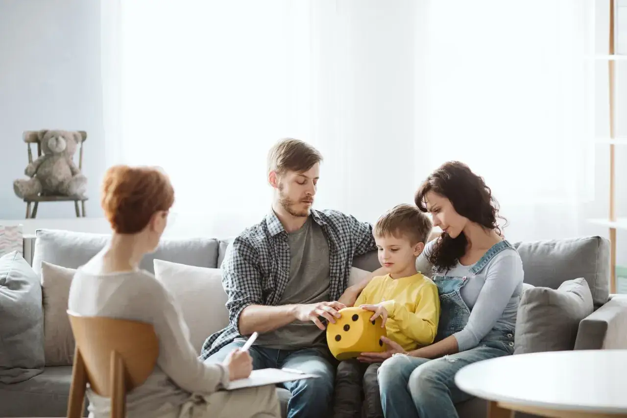 Famiglia in terapia con un bambino che tiene un dado giallo. Un percorso di speranza dove autismo si guarisce.
